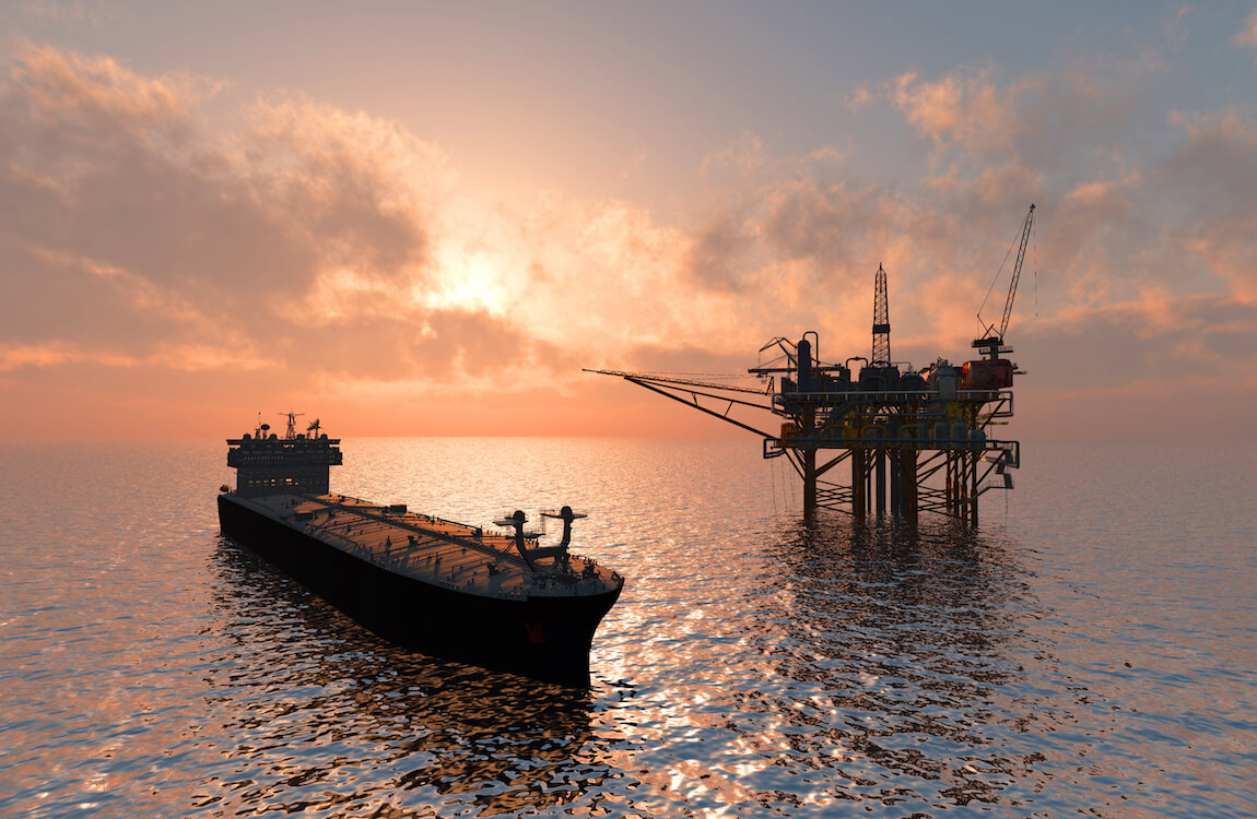 Oljefartyg och oljeplattform i solnedgång i havet.