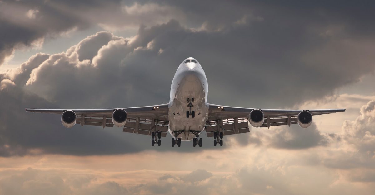 Flygplan mot rosa himmel och gråvita moln.