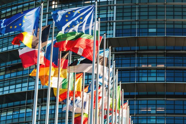 EUs flaggor vajar i solen framför parlamentsbyggnaden i Bryssel.