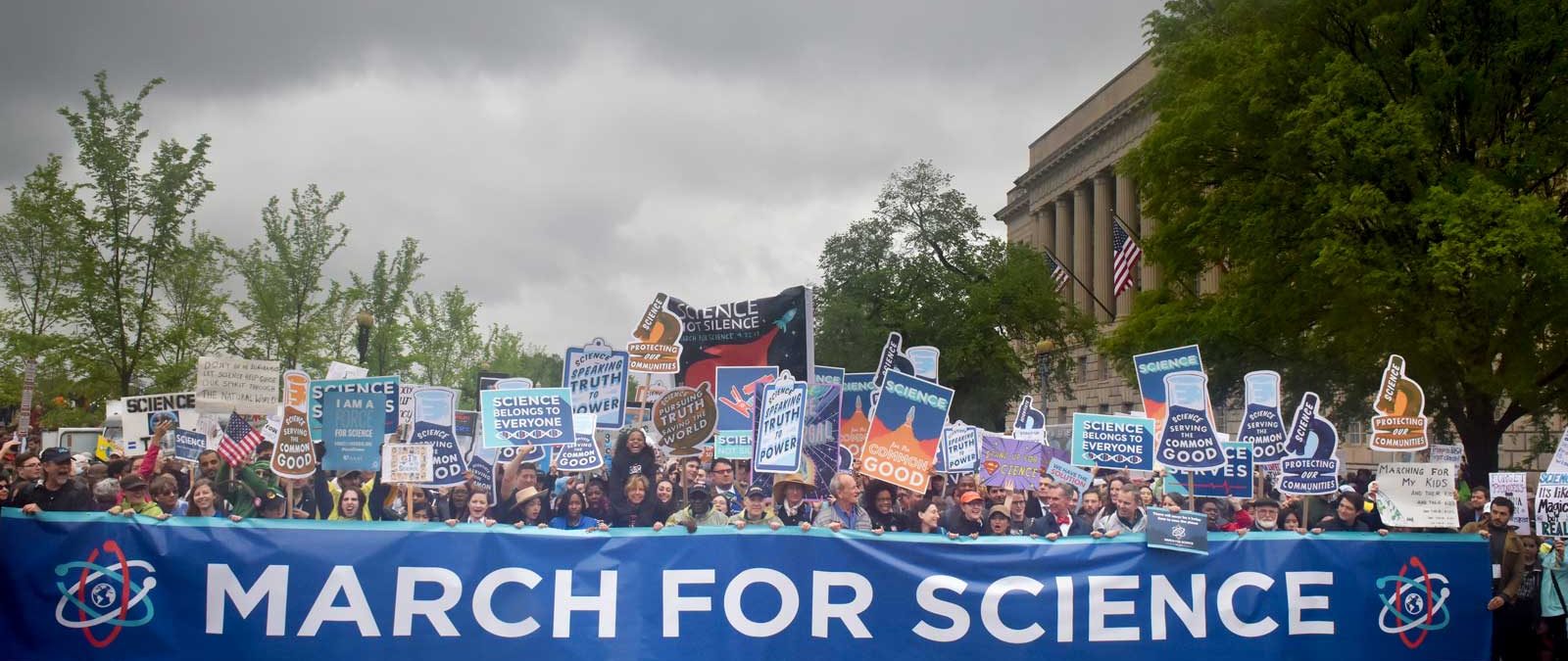 En stor uppslutning människor med plakat där det står "Science is good"och en stor banderoll där det står "March for science".