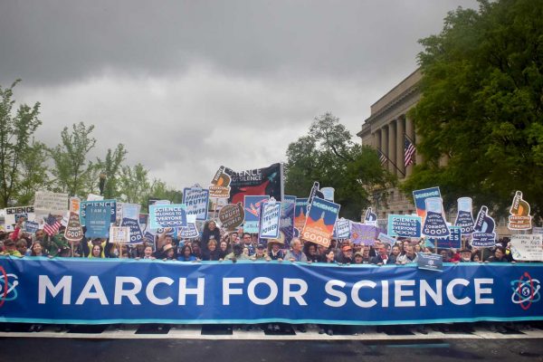 En stor uppslutning människor med plakat där det står "Science is good"och en stor banderoll där det står "March for science".