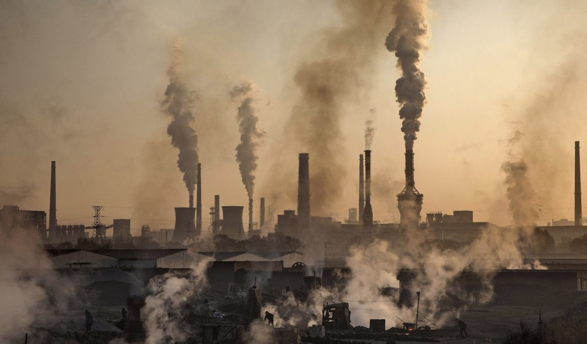 Skorstenar släpper ut grå rök över kolfabriker i Kina.