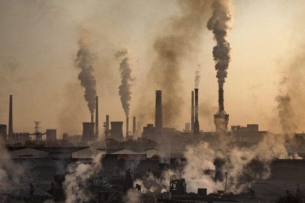 Skorstenar släpper ut grå rök över kolfabriker i Kina.