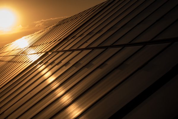 Soluppgång över ett tak med solpaneler.