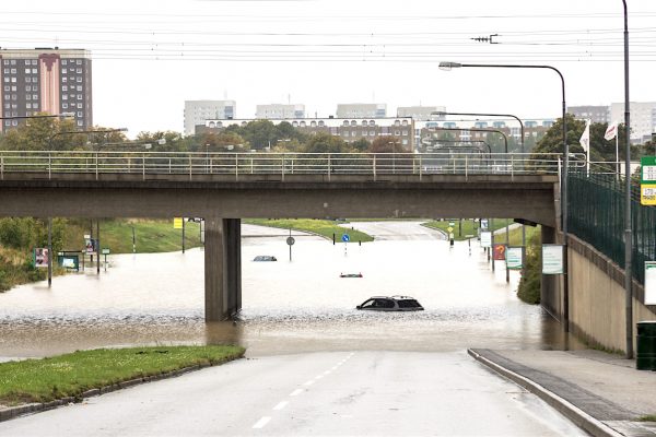 Översvämmad gata i Malmö med sjunkna bilar.