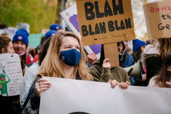 Flicka med mask på demonstration