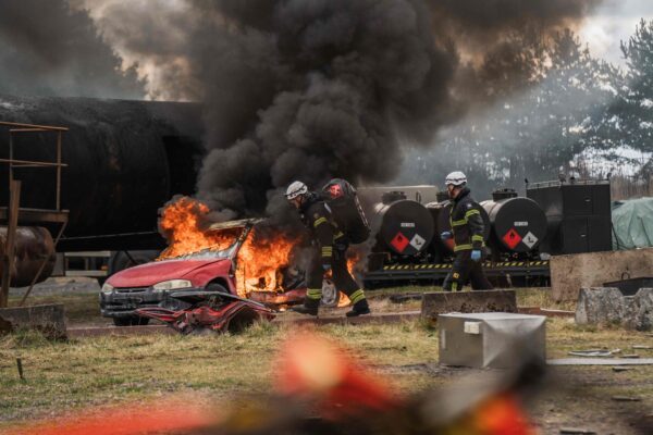Brandmän släcker brinnande bil