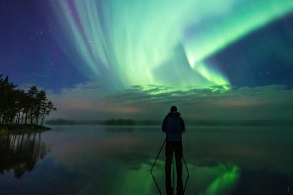 Skridskoåkare i norrsken.
