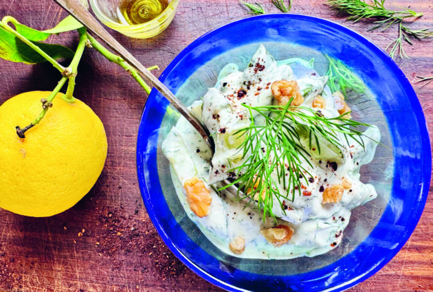 Bild på rostad gurka i dillyoghurt med en citrusfrukt bredvid.