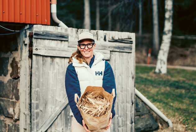 kvinna håller i säck med vete.