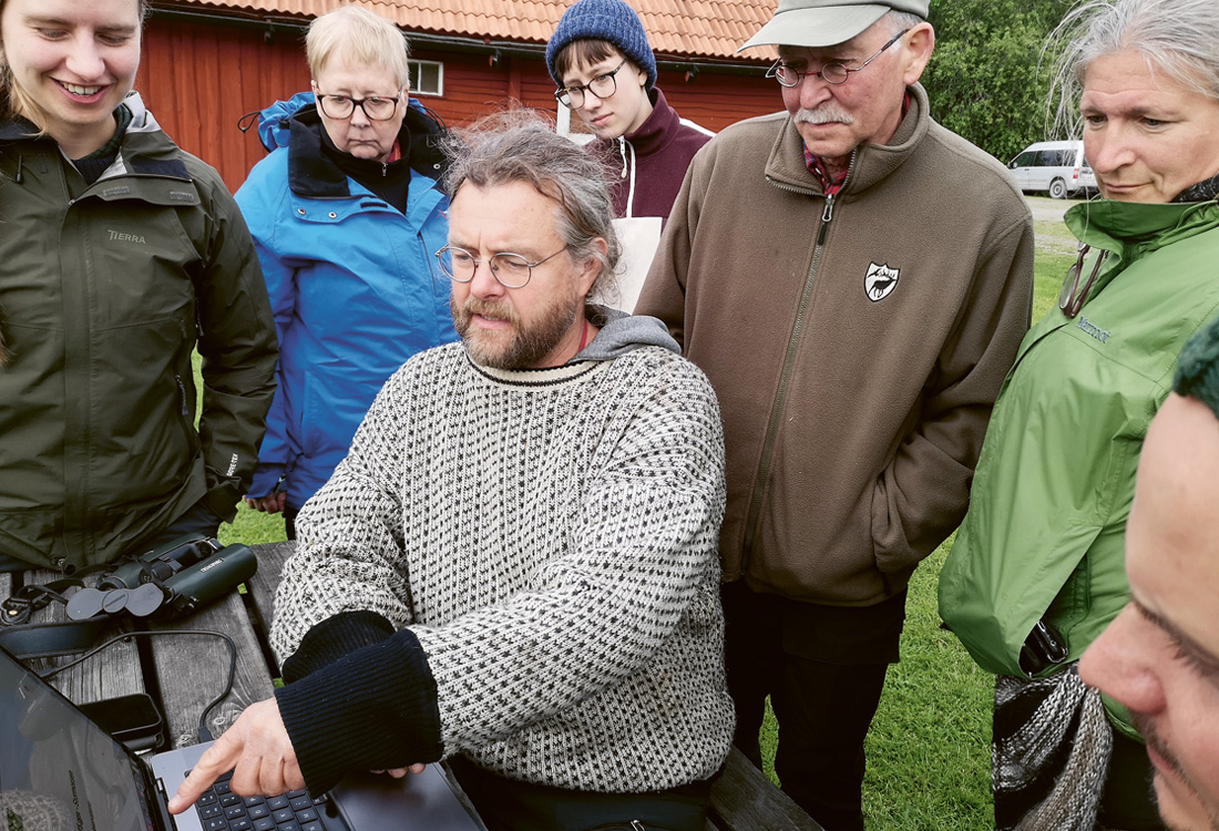 Människor runt en dator utomhus. 